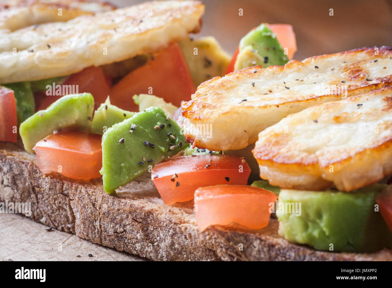 Pan agrio tostado con tomate, aguacate, y a la parrilla, Halloumi Foto de stock