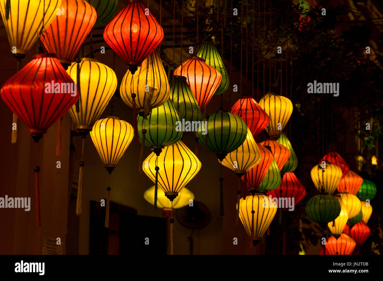 Linternas de seda multicolores brillando en la noche en Hoi An, Vietnam, conocido por sus diseños de linterna Foto de stock