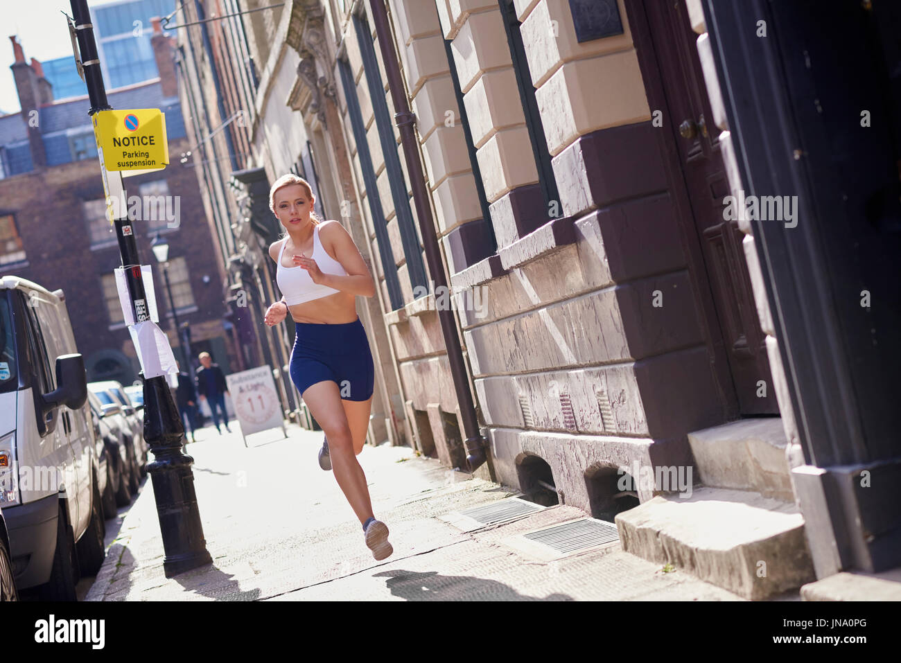 Mujer joven corriendo en entorno urbano Foto de stock