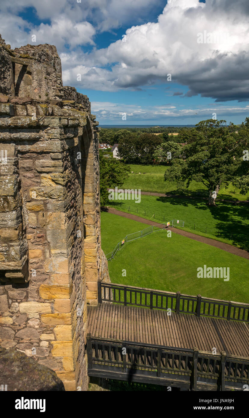 Vista de las paredes del castillo, entrada y foso, el castillo medieval Dirleton del siglo 13, East Lothian, Escocia, Reino Unido en el día de verano con nubes de cúmulos Foto de stock