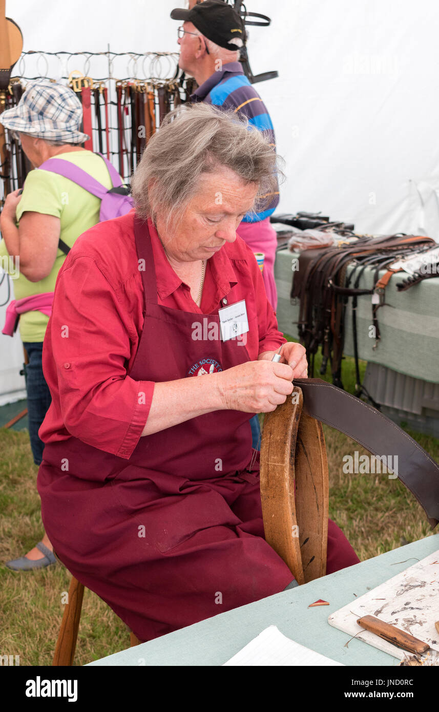 Un sillín y arnés maker en un paisaje rural y habilidades exposición en Cornwall, Inglaterra, Reino Unido. Foto de stock