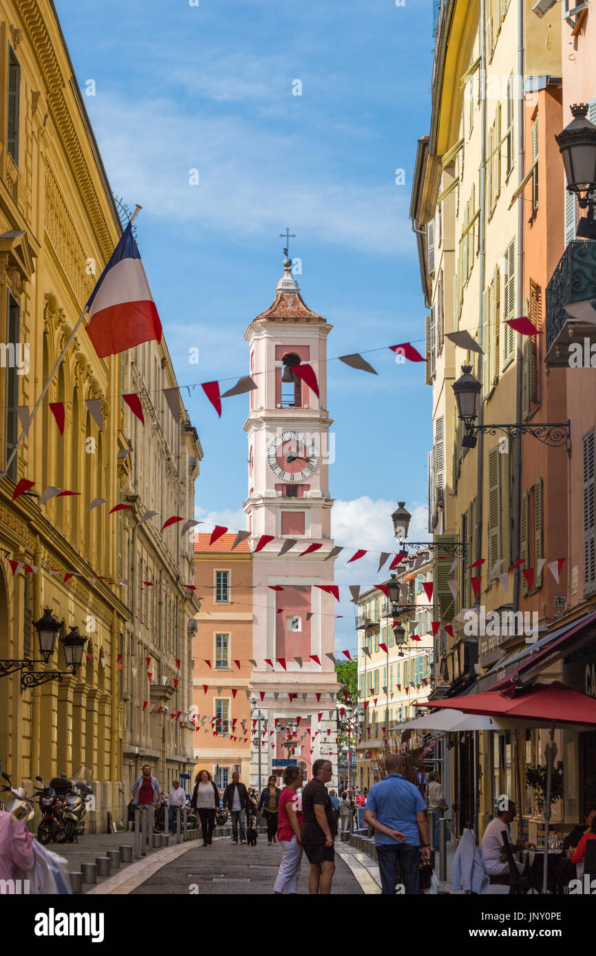 Niza, Departamento Alpes-Maritime, Francia - 10 de octubre de 2015: Street Scene en Niza, en la costa mediterránea de los Alpes Marítimos, en el sudeste de Francia. La rosa del Palacio Rusca clocktower en la distancia. Foto de stock