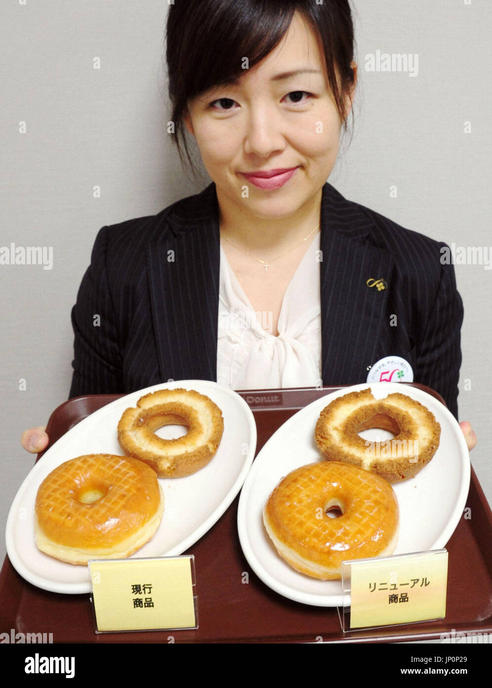 OSAKA, Japón - Foto tomada el 9 de abril de 2013, en Suita, Prefectura de Osaka, muestra los productos de Mister Donut (L) y los nuevos productos que se ponen a la venta en los EE.UU. fundada el 26 de abril la cadena de anillos. Duskin Co., operador de la cadena de anillos, dijo que cambiarán sustancialmente sus recetas de anillos para ayudar a lidiar con la debilidad de las ventas, marcando el primero de esos cambios importantes desde 1971, cuando la cadena abrió su primer establecimiento en Japón. (Kyodo) Foto de stock