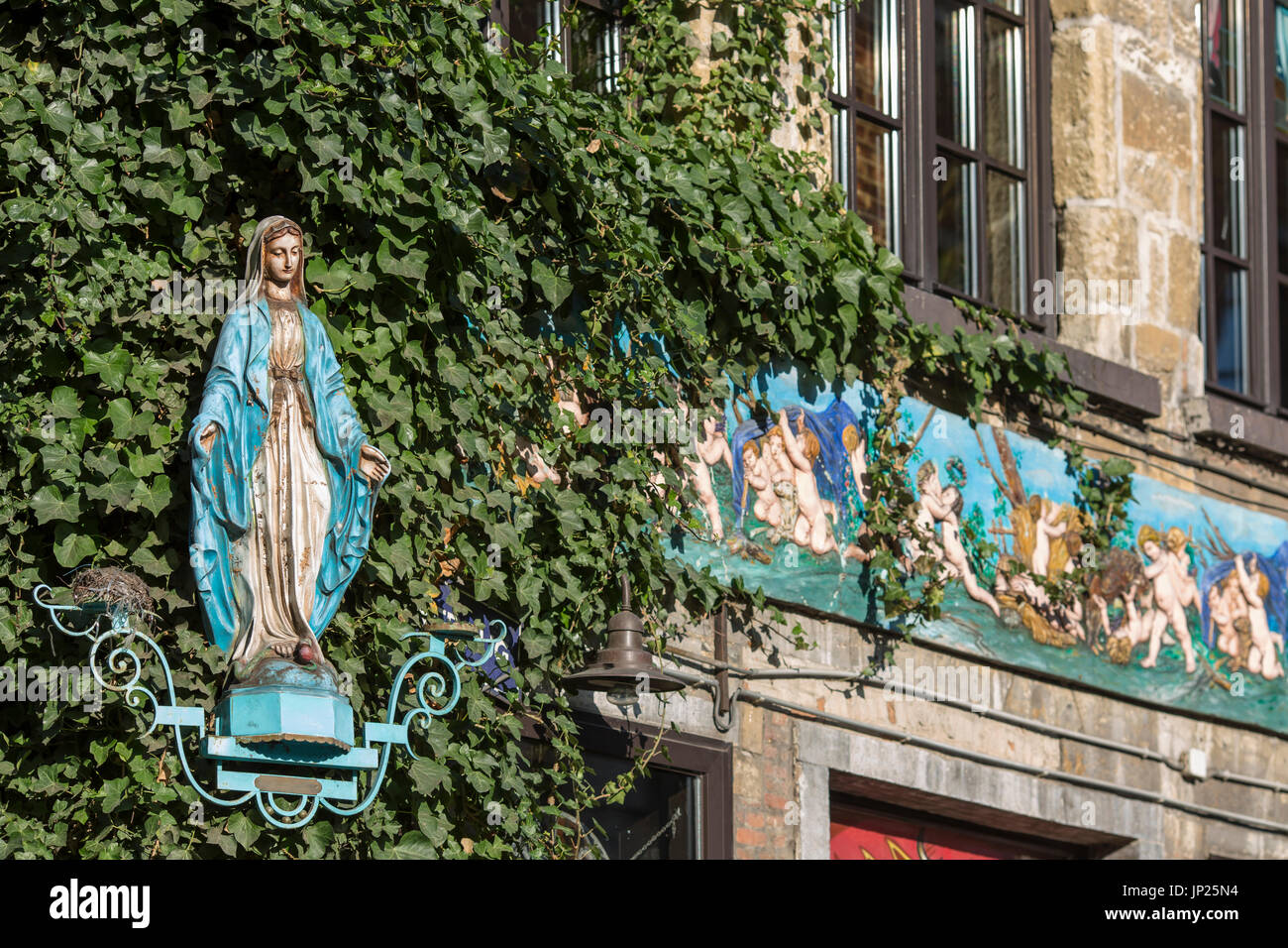 Amberes, Bélgica - 9 de marzo de 2014: Católica efigie y bajorrelieves con decoración en edificio viejo en Amberes, Bélgica. Foto de stock