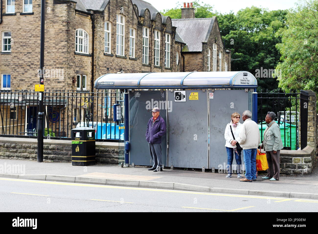 Gente esperando en una parada de autobús en Chesterfield Road, Sheffield Foto de stock