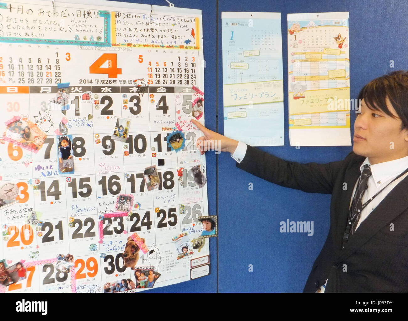 Tokio, Japón - un funcionario en Todan Co., un calendario maker en Tokio, desvela los diversos calendarios para 2015 El 19 de diciembre de 2014, incluyendo una gran uno fácilmente visible para personas con visión deficiente. (Kyodo) Foto de stock
