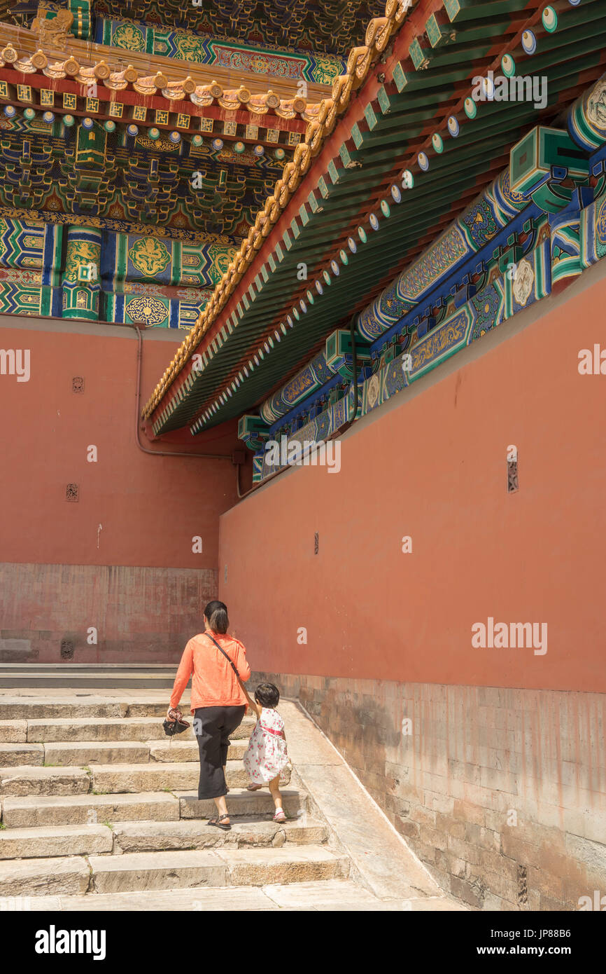 Madre e hija turistas subir escalones en el Hall de la Suprema Armonía de la Ciudad Prohibida Foto de stock