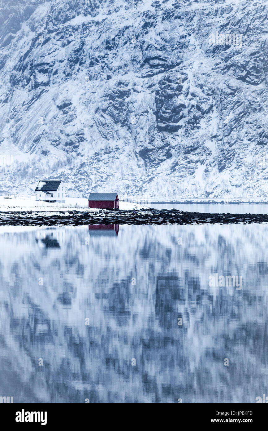 Reflejo perfecto de las montañas y la casa roja, Islas Lofoten, Noruega Foto de stock