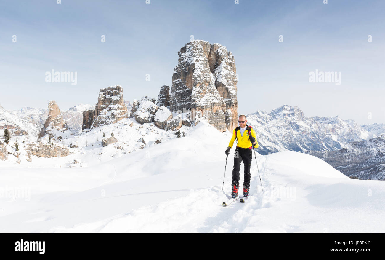Una vista de un esquiador durante una excursión de esquí de montaña con el Cinque Torri, en el fondo, de la provincia de Belluno, Véneto, Italia, Europa Foto de stock
