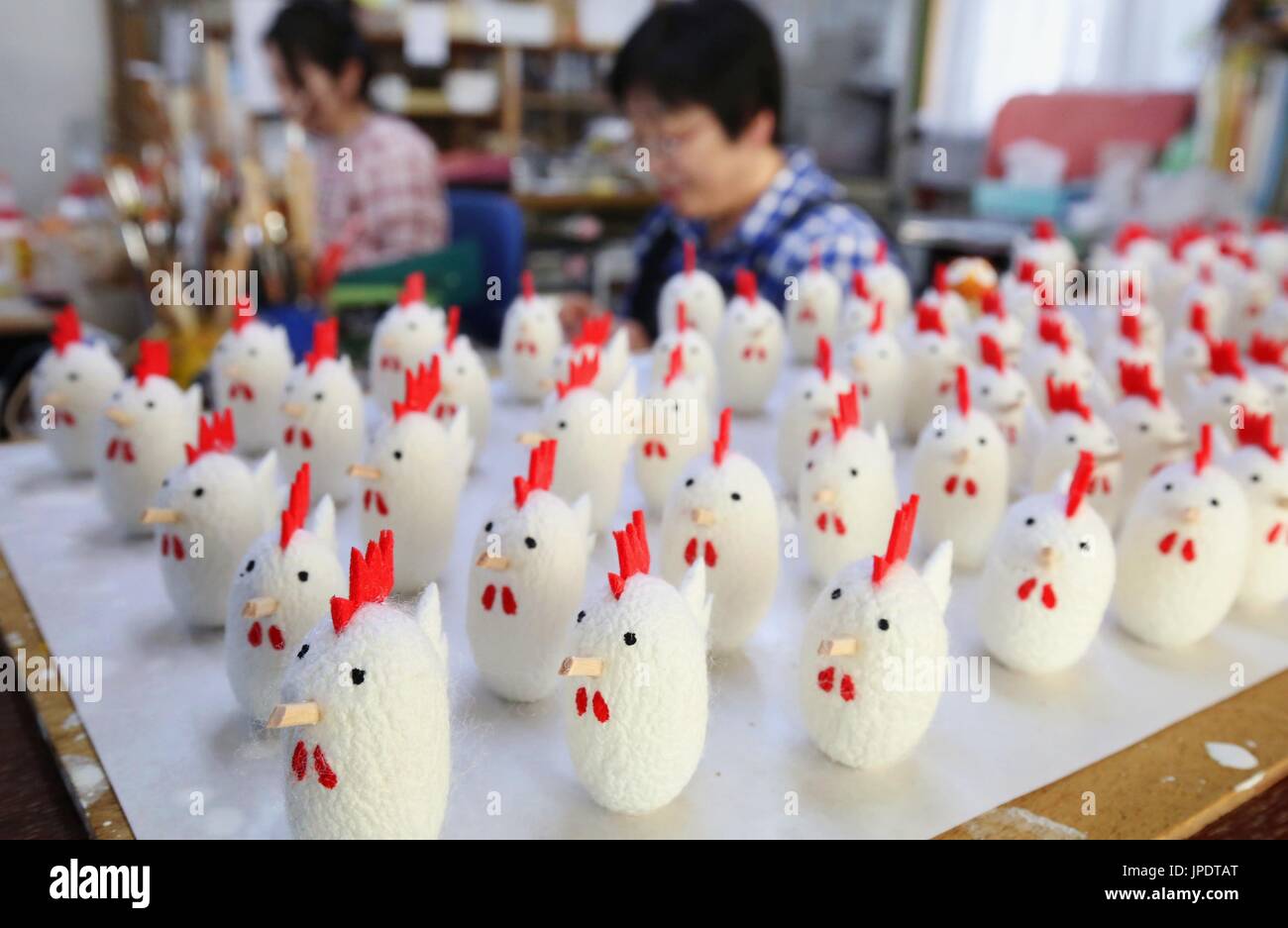 Rooster muñecos hechos de "Cocoon pelotas" -- un año nuevo tradicional  ornamento -- sentarse en una mesa en Morioka, Japón el 21 de diciembre,  2016, por delante de el Año del Gallo