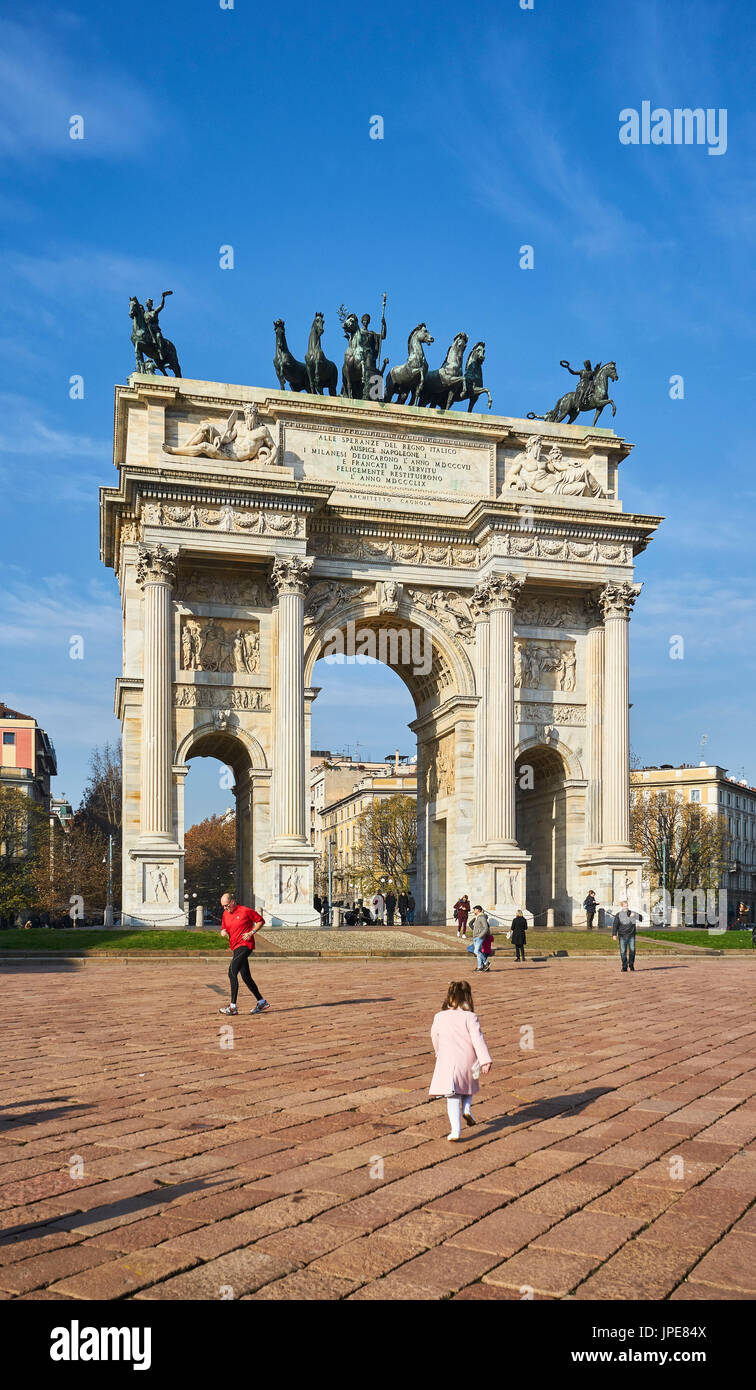 Milan, Italia. Un niño se ejecute en el arco de la plaza de la paz. Foto de stock