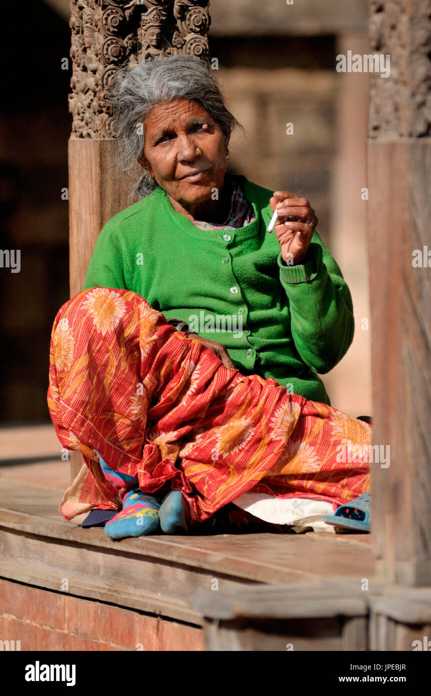 Una mujer nepalesa, relajarse a sí misma en un templo en la Plaza Durbar de Bhaktapur, Nepal Foto de stock