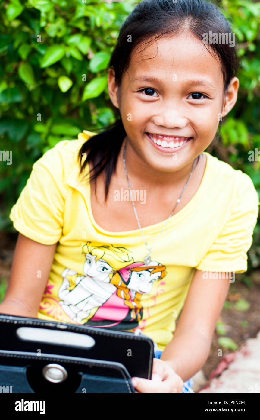 Niña con pequeñas tabletas, cerca de la catedral, Puerto Princesa, Palawan, Filipinas Foto de stock