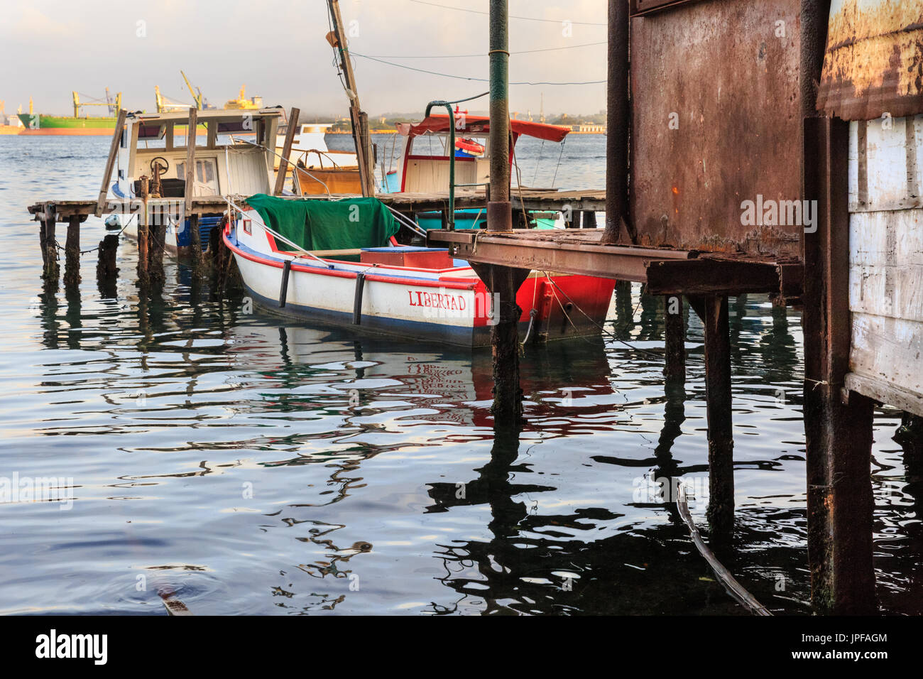 Barcos de pesca y cabañas junto al puerto en el tranquilo, frente al barrio de Habana, en Casa Blanca, La Habana, Cuba Foto de stock