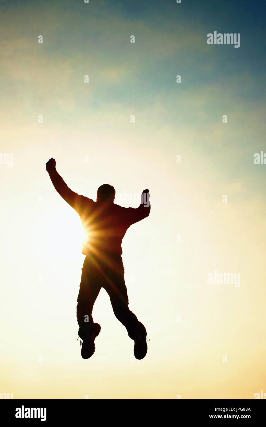 Hombre volar en el aire. El hombre cayendo con las manos arriba. Sol y