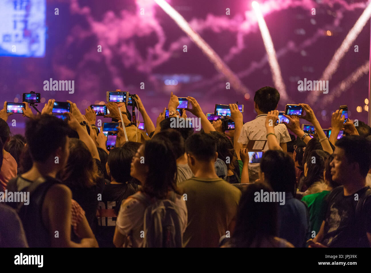 Multitud de pueblos asiáticos fuegos artificiales de grabación de vídeo en teléfonos móviles en lugar de mirar directamente. En el 20º aniversario del regreso de Hong Kong a China. Foto de stock