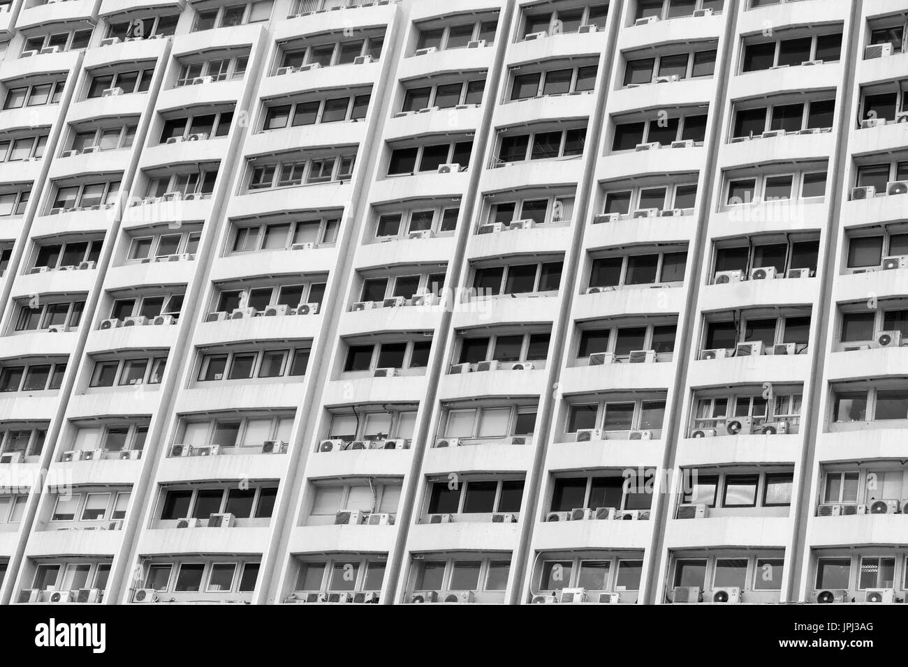 Acondicionadores de aire montado en la mayoría de las ventanas de un edificio residencial de gran altura en Hong Kong Foto de stock