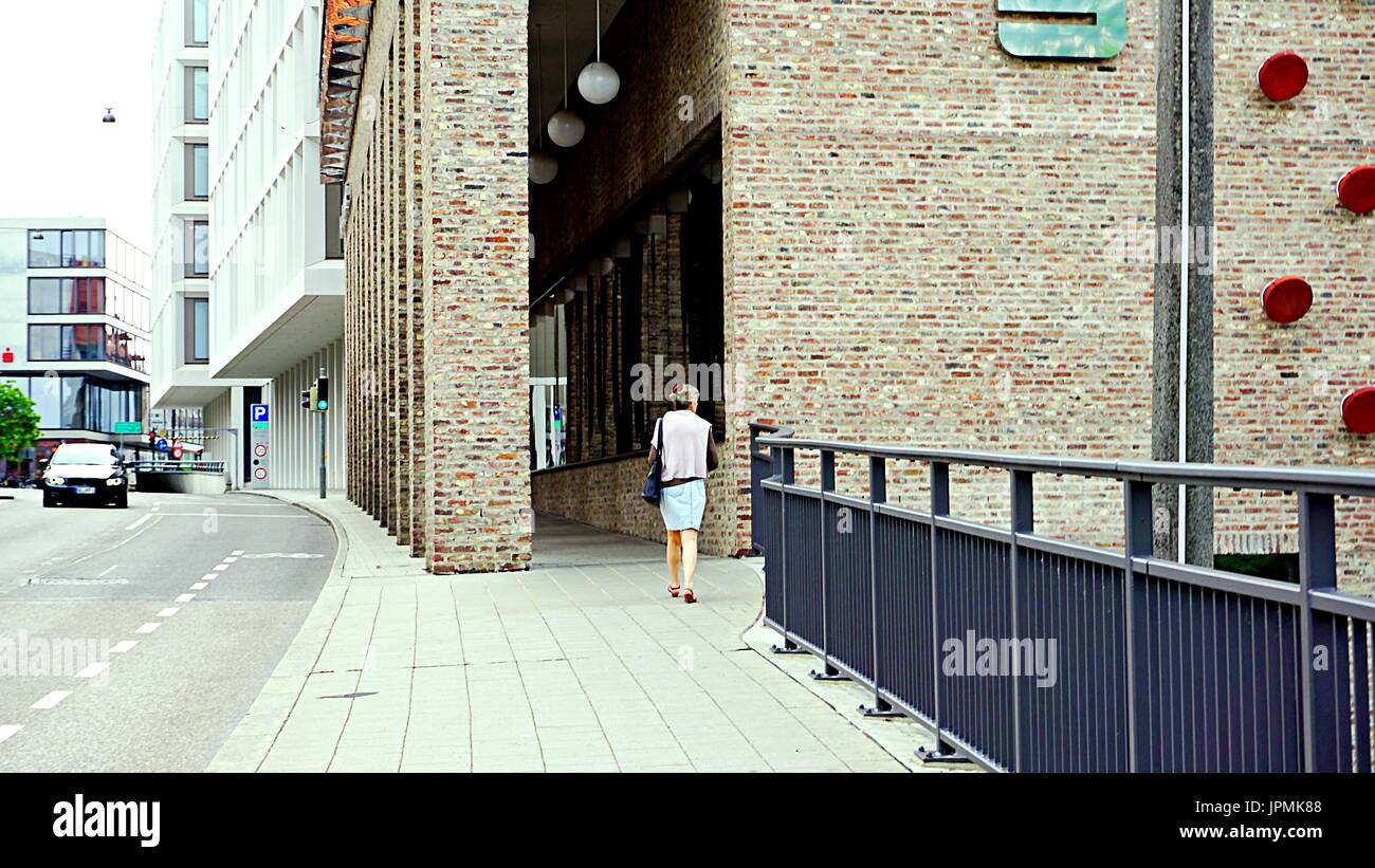Una mujer desconocida caminando hacia el edificio de negocios en Ulm, Alemania Foto de stock