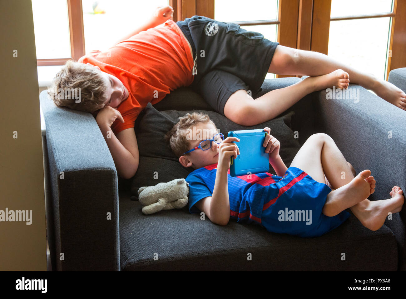 Young Boy jugando Juego de ordenador en el iPad con otro chico mirando Foto de stock