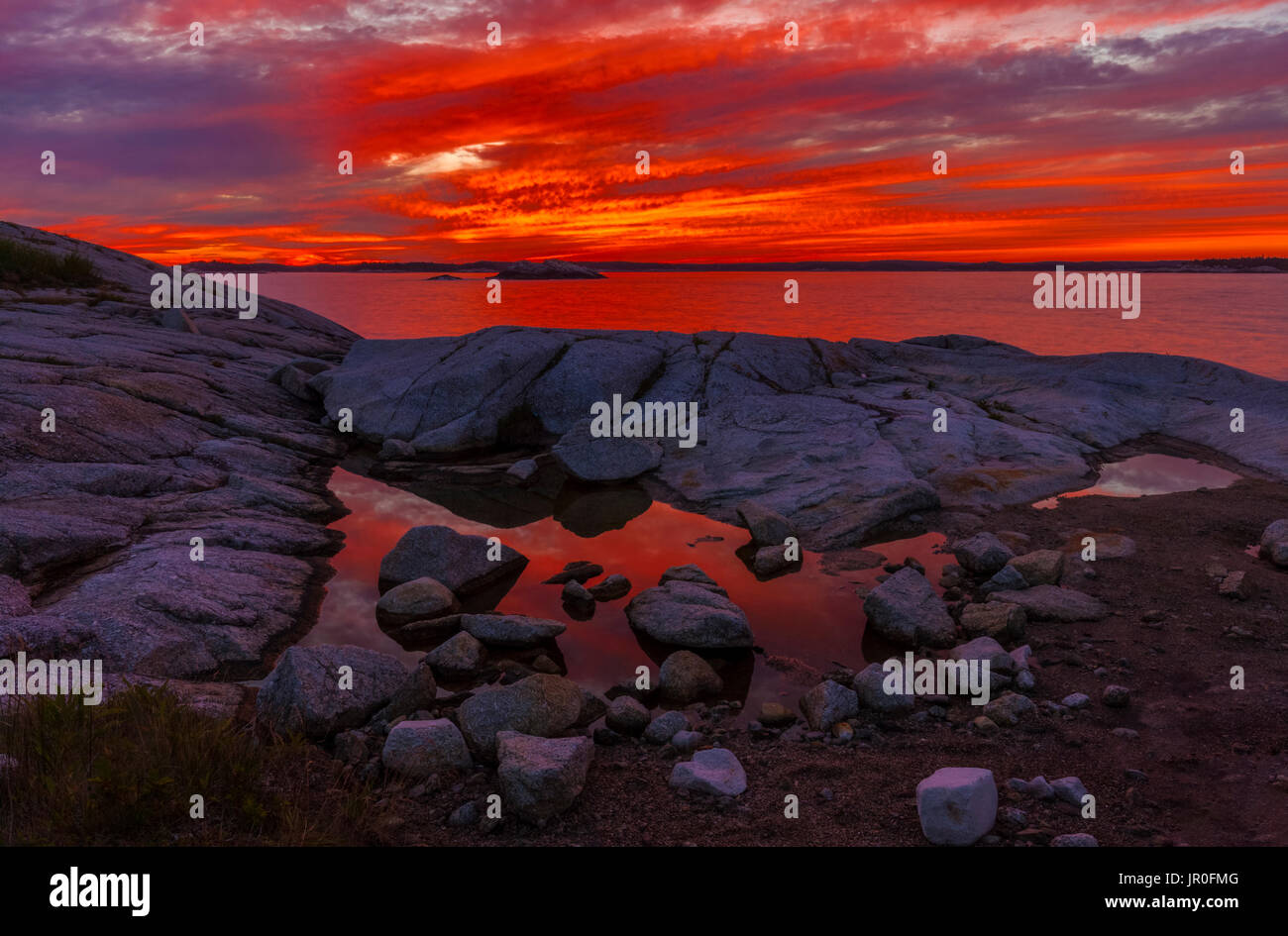Cielo Rojo cereza al atardecer y ver a lo largo de la costa, cerca de la cabeza alta Trail; Perspectiva, Nova Scotia, Canadá Foto de stock