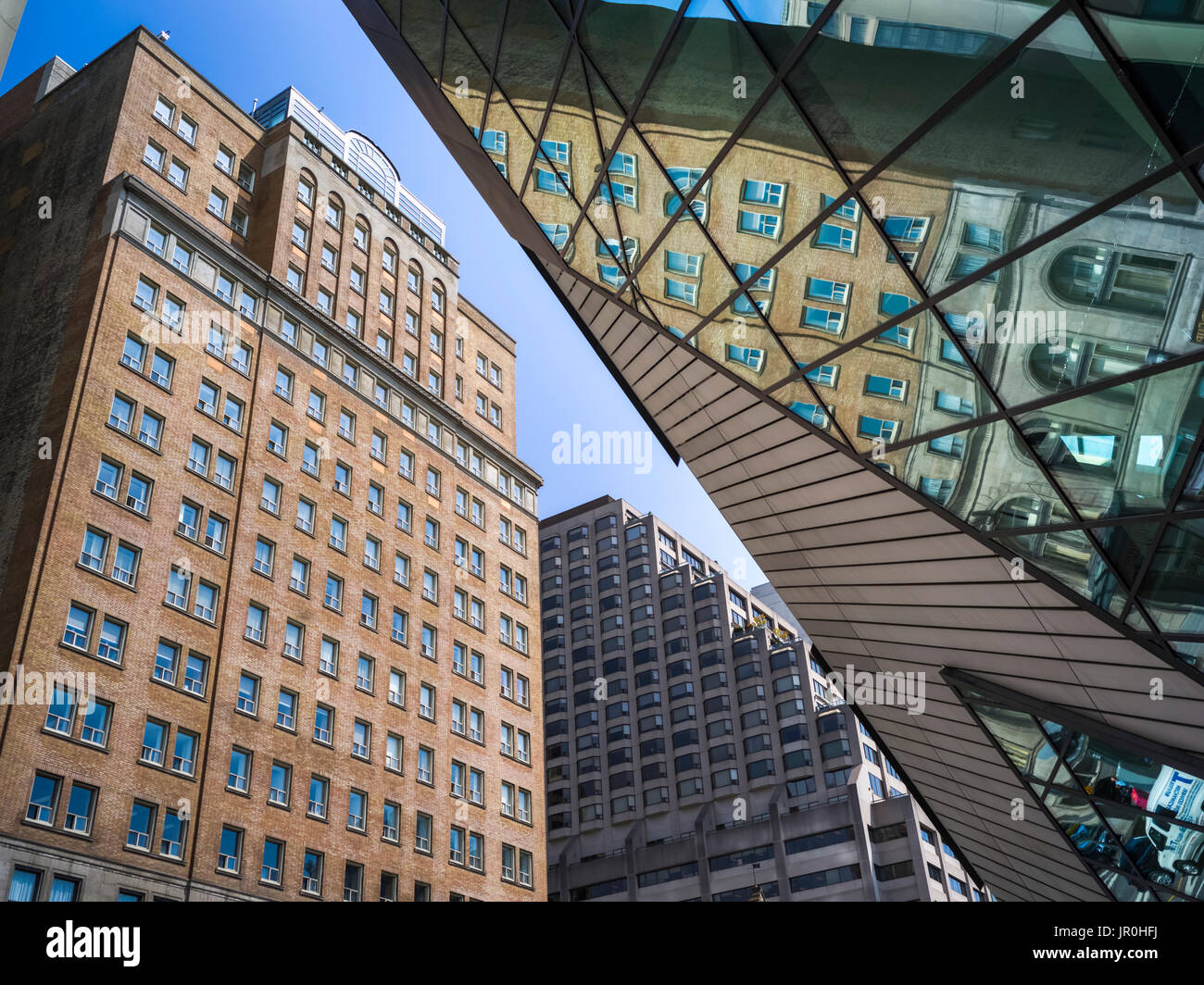 Ángulo de visión baja de edificios y un reflejo en la fachada de vidrio del Royal Ontario Museum, Toronto, Ontario, Canadá Foto de stock