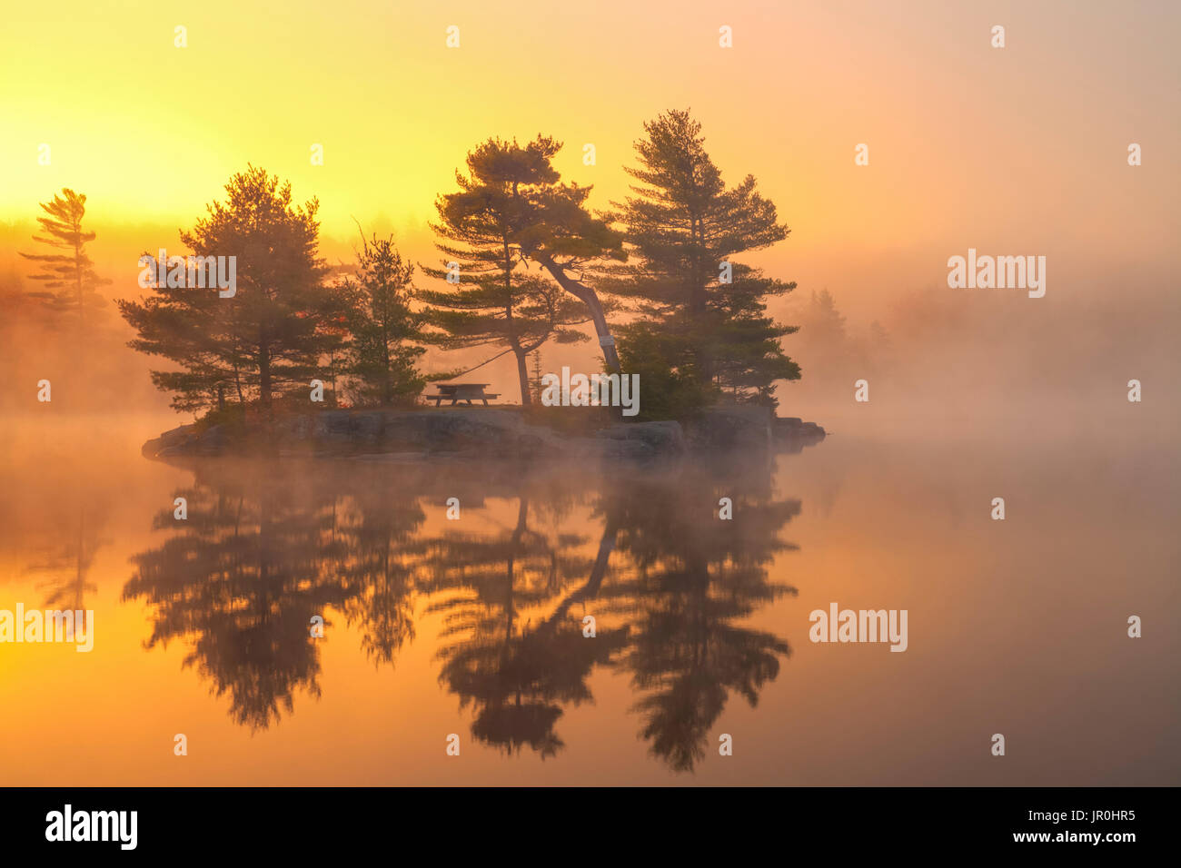 Misty Octubre Amanecer y la isla en el lago de dólar, Dólar Lake Provincial Park, Nova Scotia, Canadá Foto de stock