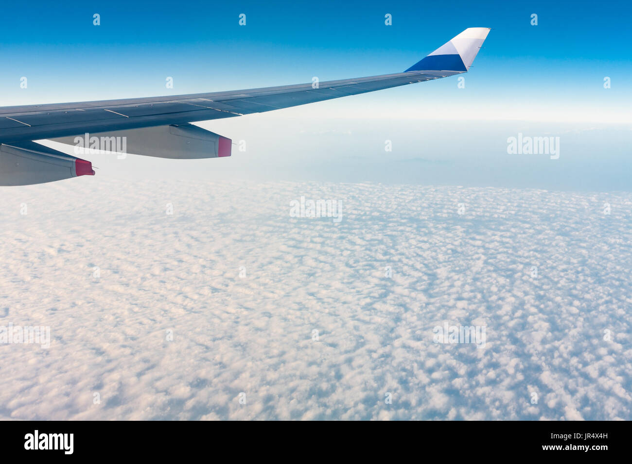 La aleta de un avión Airbus A330-300 de China Airlines IC-917 en vuelo, por encima de las nubes estratocúmulos, contra el cielo azul, volar desde Taiwán a Hong Kong Foto de stock