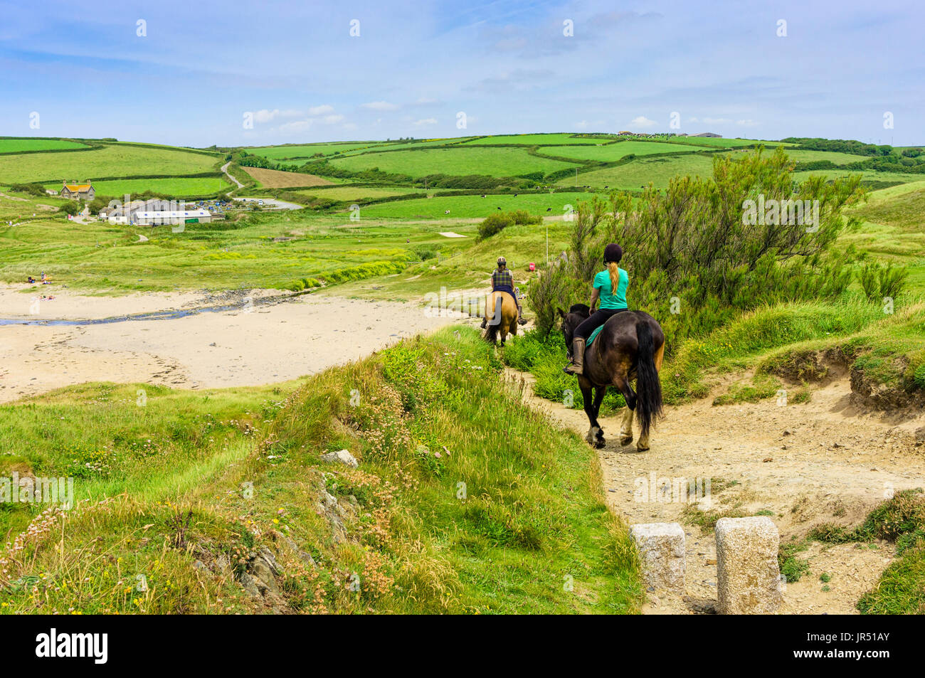 Montar a caballo en la costa sur oeste de camino a la playa Gunwalloe, península de Lizard, Cornualles, en el Reino Unido en verano Foto de stock