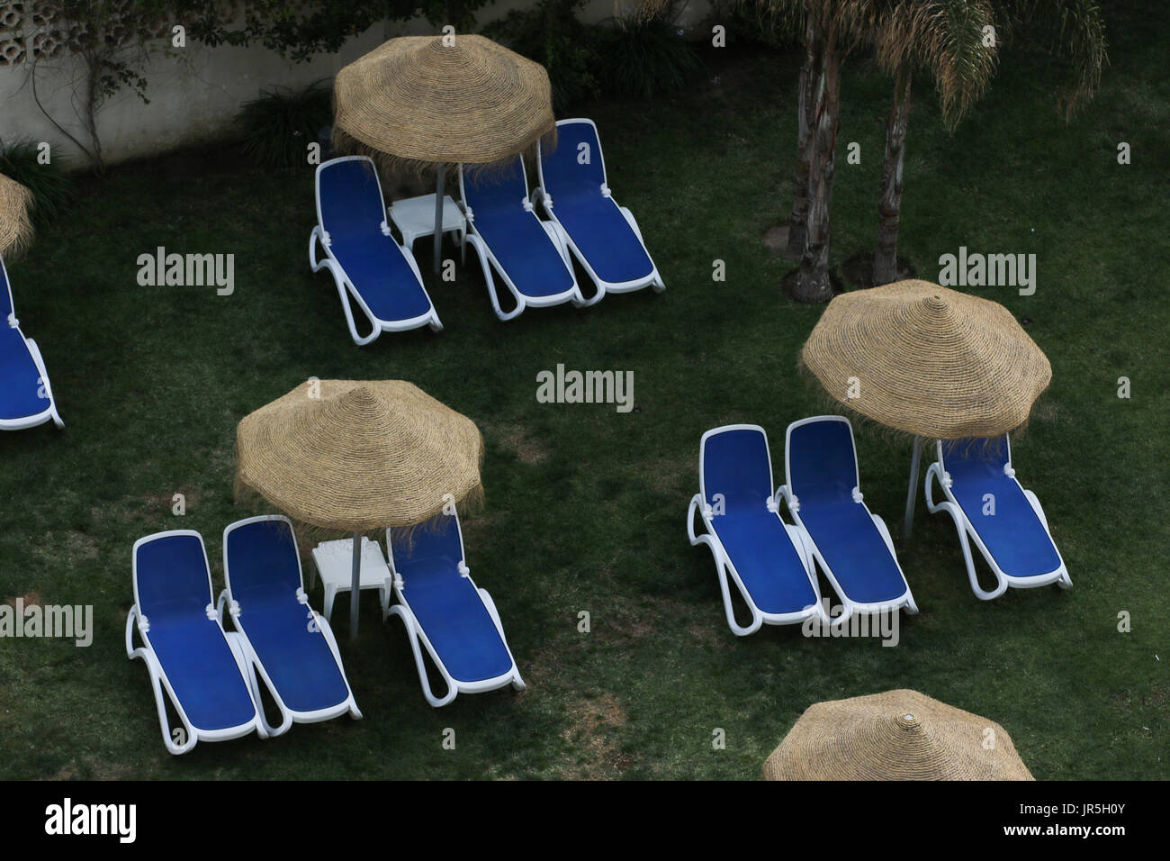 Hamacas en un hotel de la zona de la piscina con sombrillas sobre ellas  Fotografía de stock - Alamy