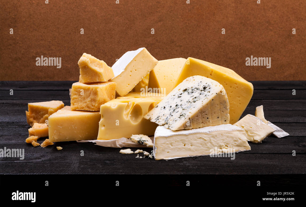 Diversos tipos de queso en la mesa de madera rústica Foto de stock