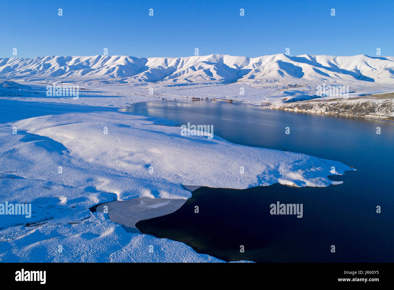 Falls Dam y gama Hawkdun en invierno, Maniototo, Central Otago, Isla del Sur, Nueva Zelanda - antena drone Foto de stock
