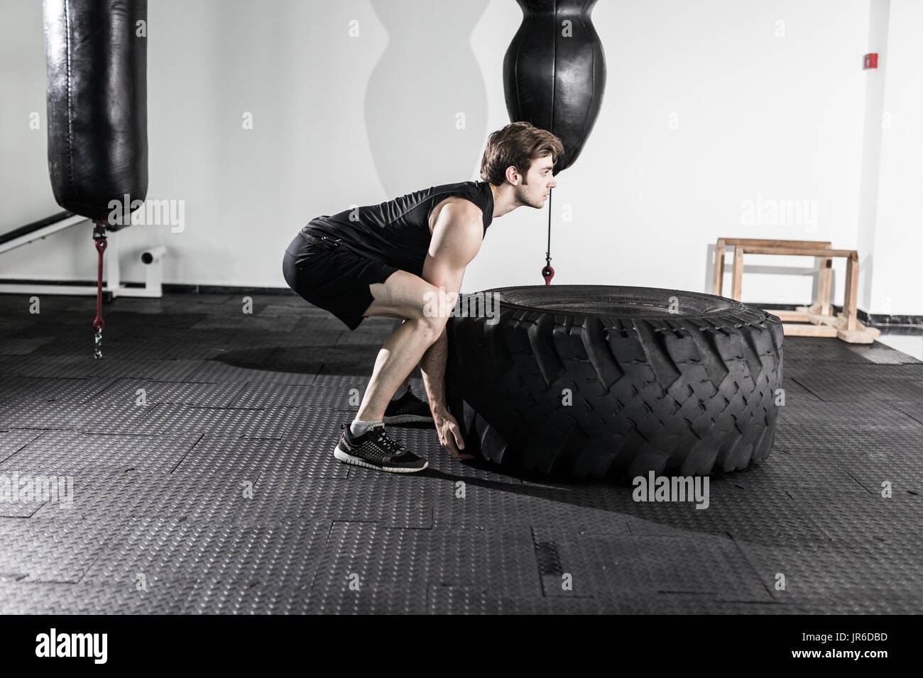Entrenamiento Crossfit - hombre volteando neumático en gimnasio Fotografía  de stock - Alamy
