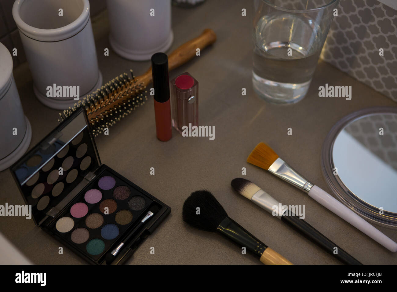 Un alto ángulo de visualización de productos de belleza con vaso para beber en la mesa Foto de stock