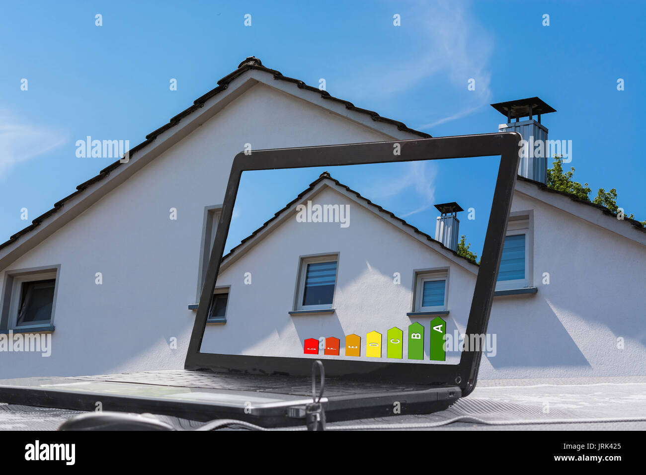 Portátil con imagen de una casa en el monitor. Desarrollar conceptos de diseño y arquitectura. Foto de stock