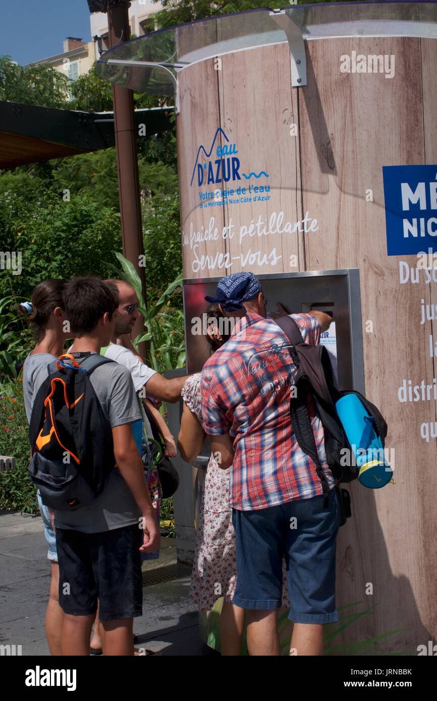 Turistas que reciben agua potable fresca de un quiosco de agua, Niza, Francia Foto de stock