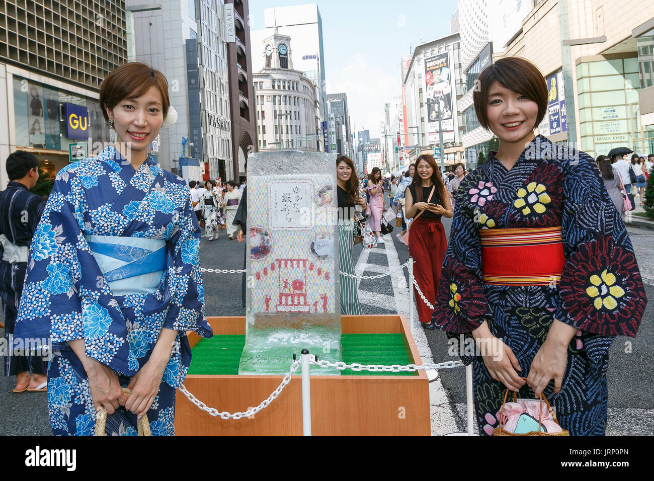 Las personas vistiendo yukata, una versión de verano de los kimonos, posan  para una fotografía en el distrito comercial de Ginza de Tokio, el 6 de  agosto de 2017, en Tokio, Japón.