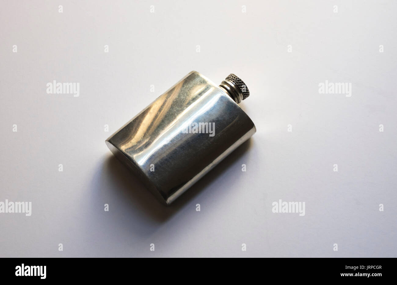 Un viejo frasco de acero inoxidable para llevar licores en un bolsillo trasero Foto de stock