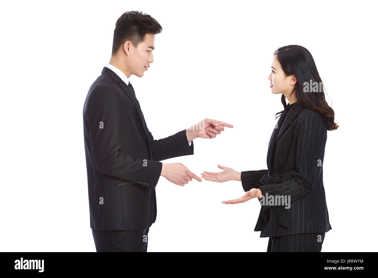 Joven Hombre y mujer de negocios asiáticos en desgaste formal tiene un argumento serio, aislado sobre fondo blanco. Foto de stock