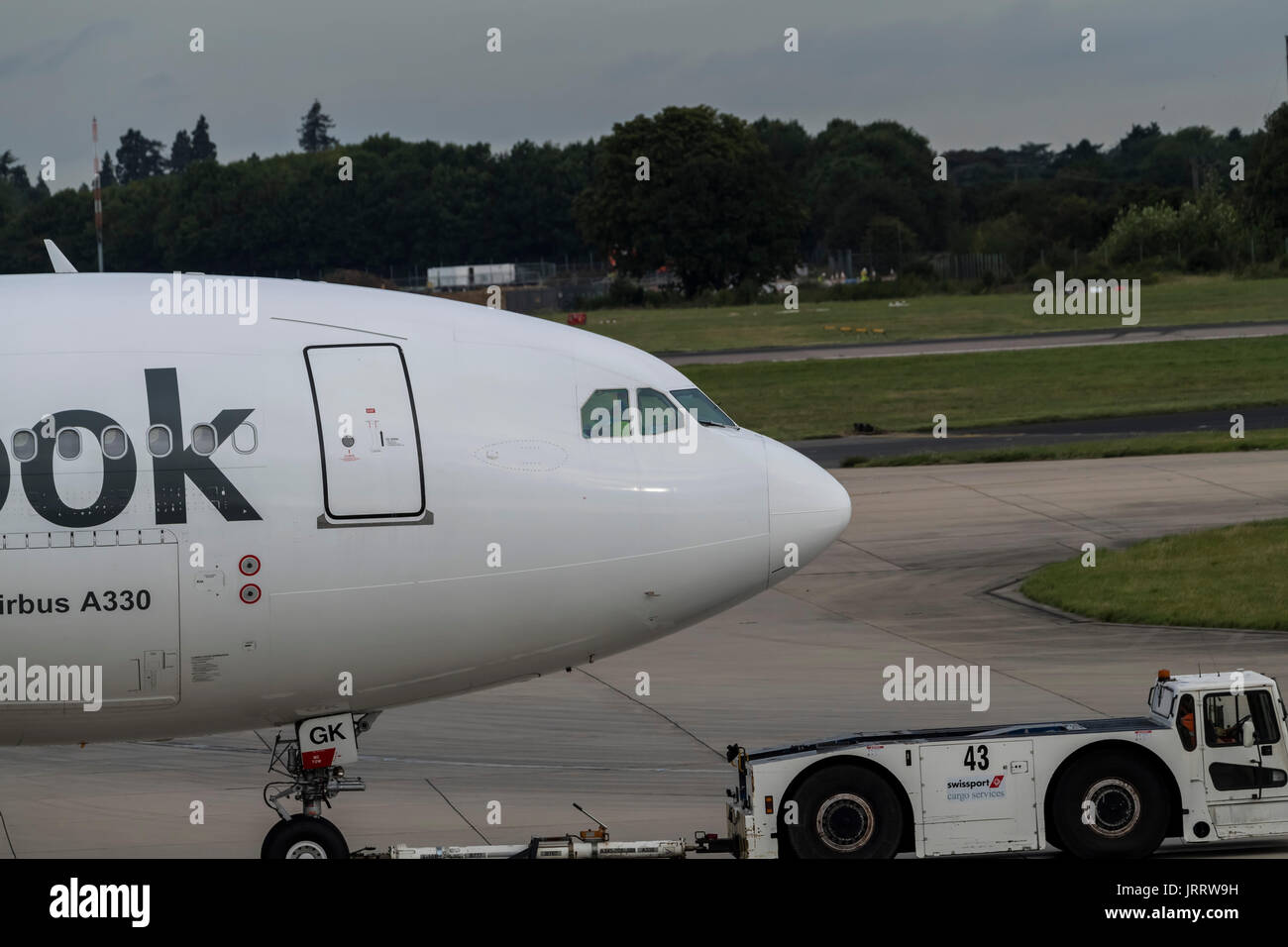 Un Airbus A330-243 de Thomas Cook es tirado por un camión remolcador al aeropuerto de Stansted de Londres Foto de stock