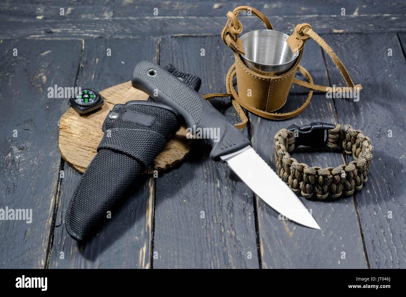 Un cuchillo militar de supervivencia, un brazalete de metal y