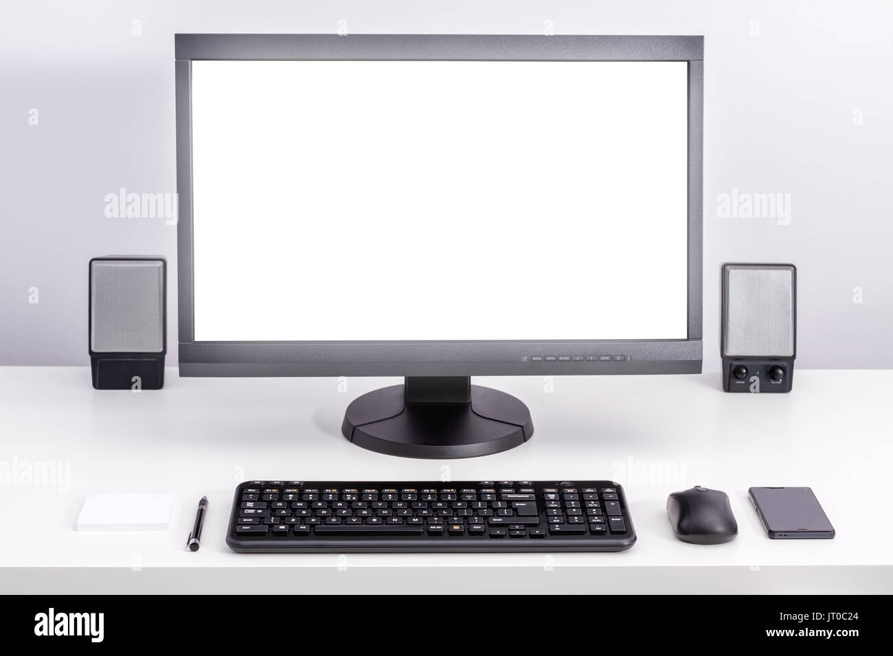 Monitor de pc en blanco Blanco permanezca en el escritorio, todo ordenado  espacio para trabajar con el teclado, el ratón del ordenador, smartphone,  altavoces, pen y notas adhesivas Fotografía de stock -