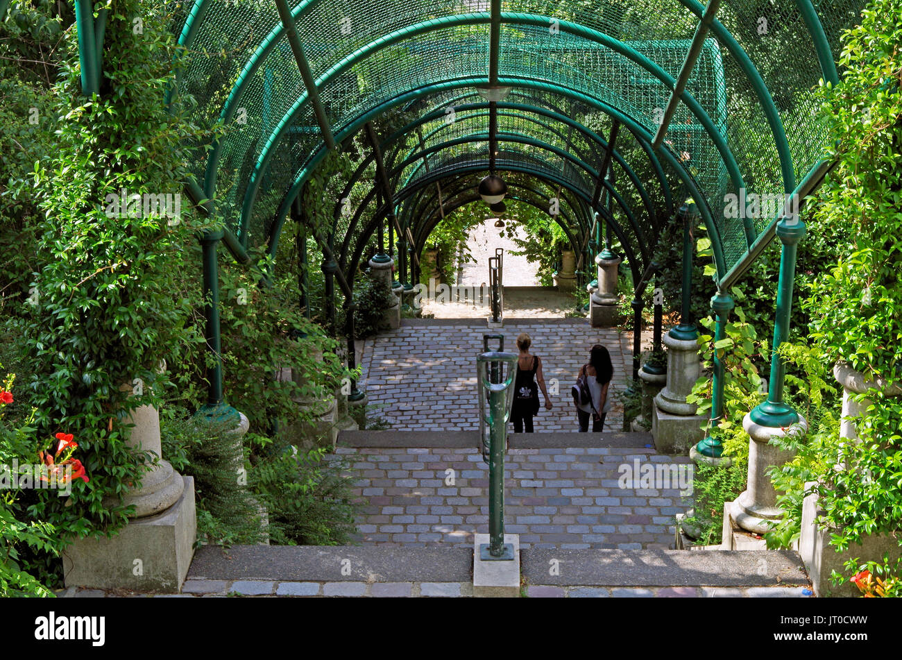 Parque de Belleville, París Francia, larga escalera de ladera, con arcos enrejados y siembra densa, casi exactamente en la línea de rueVilin, en Foto de stock