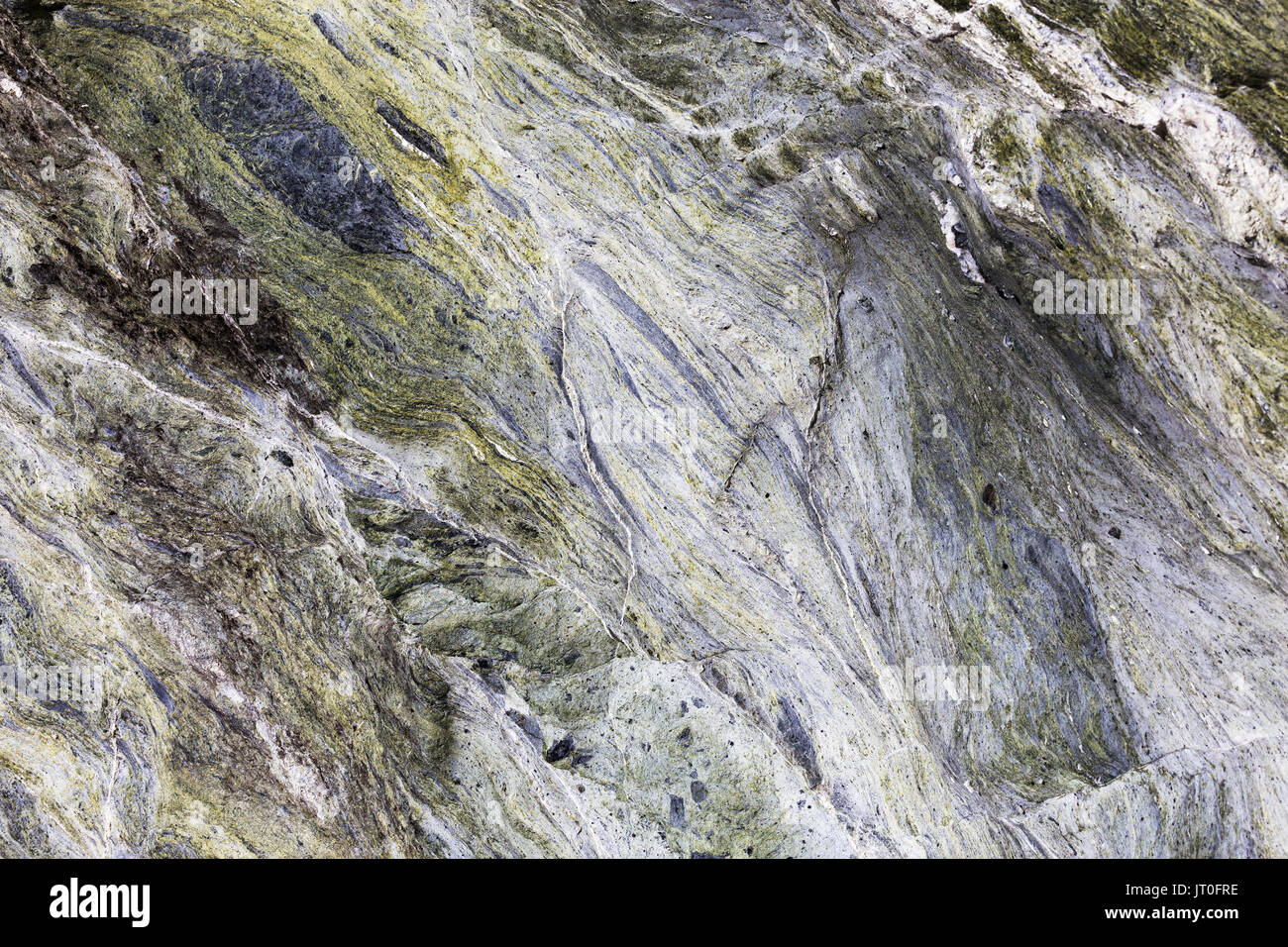 Un resumen cerca de vetas de minerales ejecutando a través de Roca Verde en un fondo de textura. Foto de stock