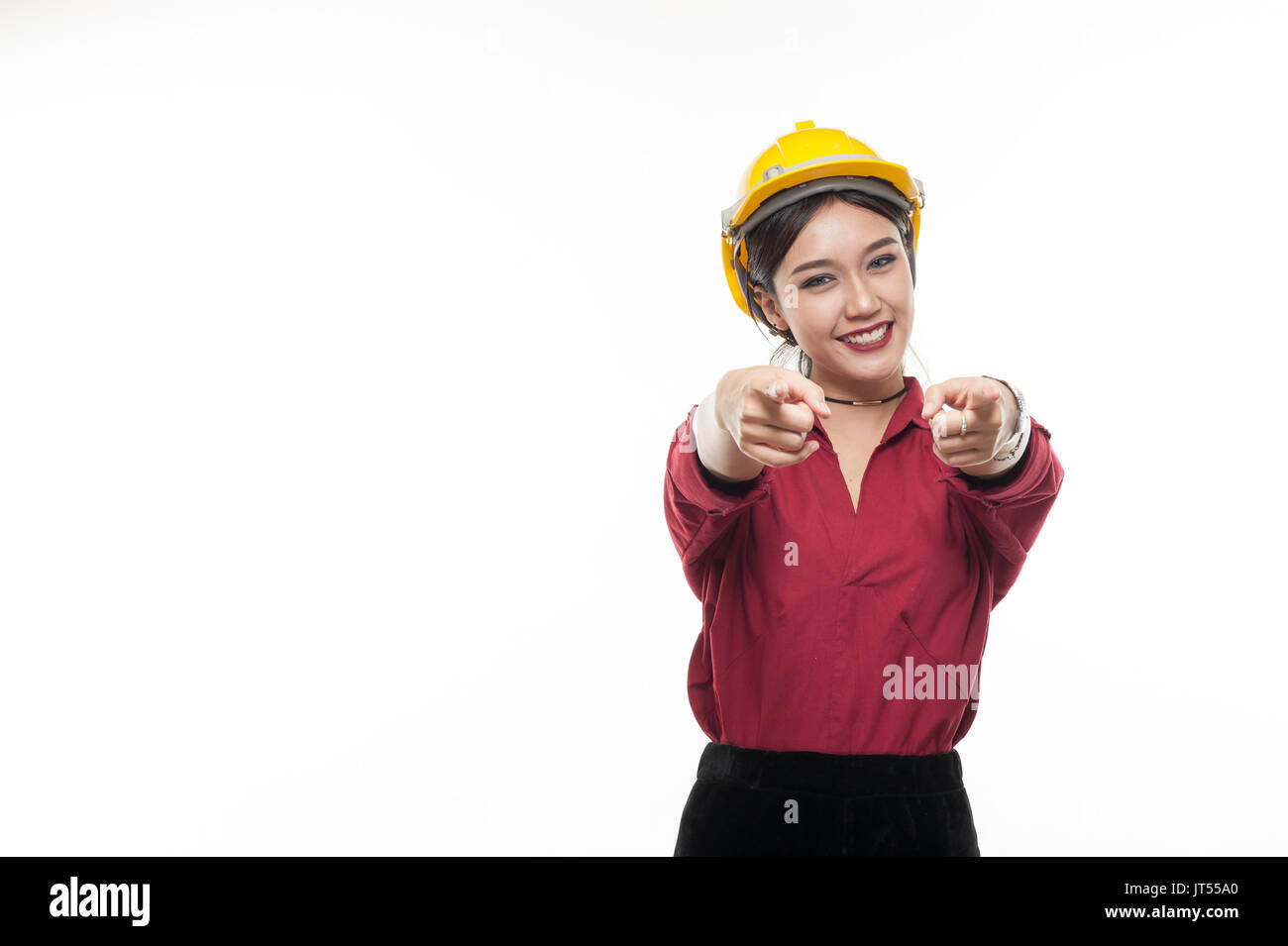 Mujer asiática ingeniero en camiseta roja y amarilla caja tapa delantera apuntando con emoción feliz. la gente gesticula en negocios y concepto enginerring Foto de stock