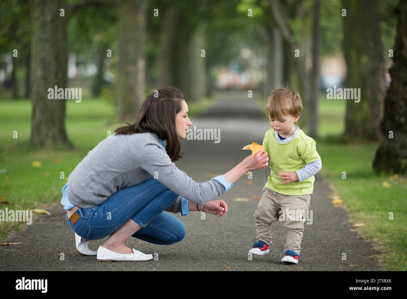Madre feliz jugando con su niño pequeño al aire libre. Concepto de amor y solidaridad. Foto de stock