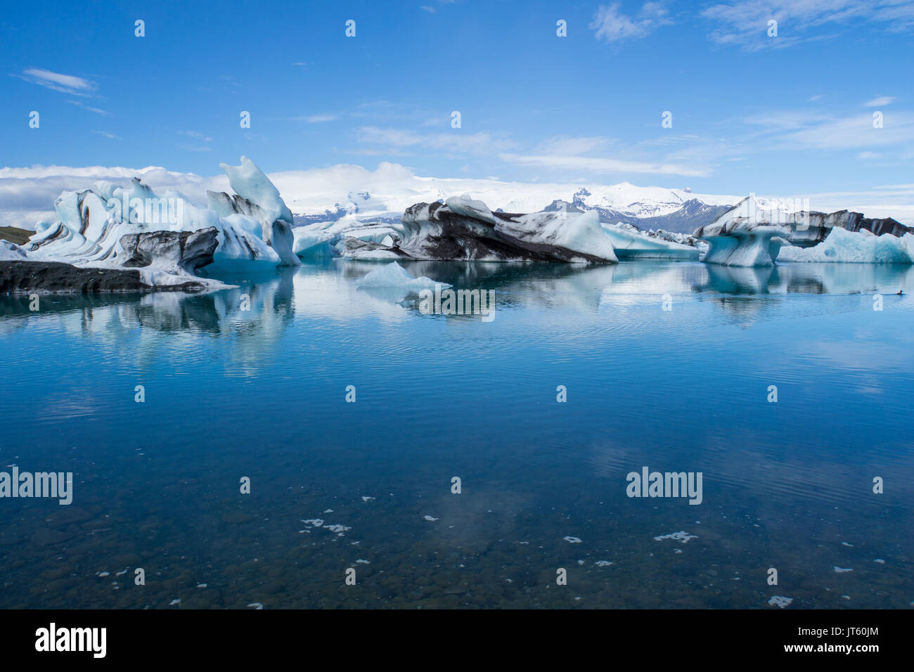 Islandia - Gigantescos témpanos de hielo en la laguna glaciar joekulsarlon con cielo azul Foto de stock