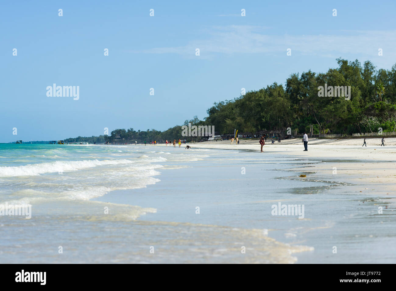 Playa tropical con palmeras y gente en segundo plano, Diani, Kenya Foto de stock