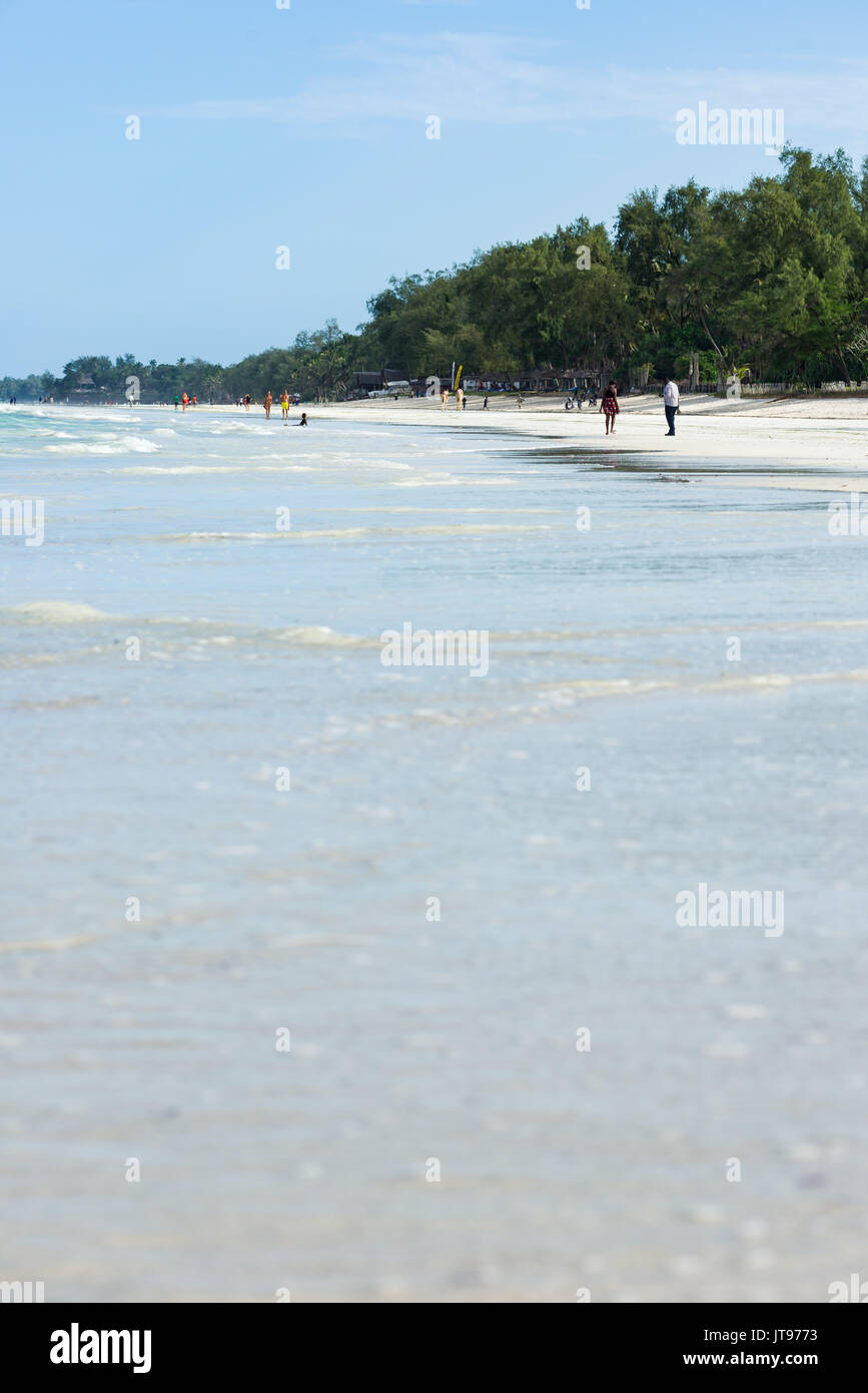 Playa tropical con palmeras y gente en segundo plano, Diani, Kenya Foto de stock