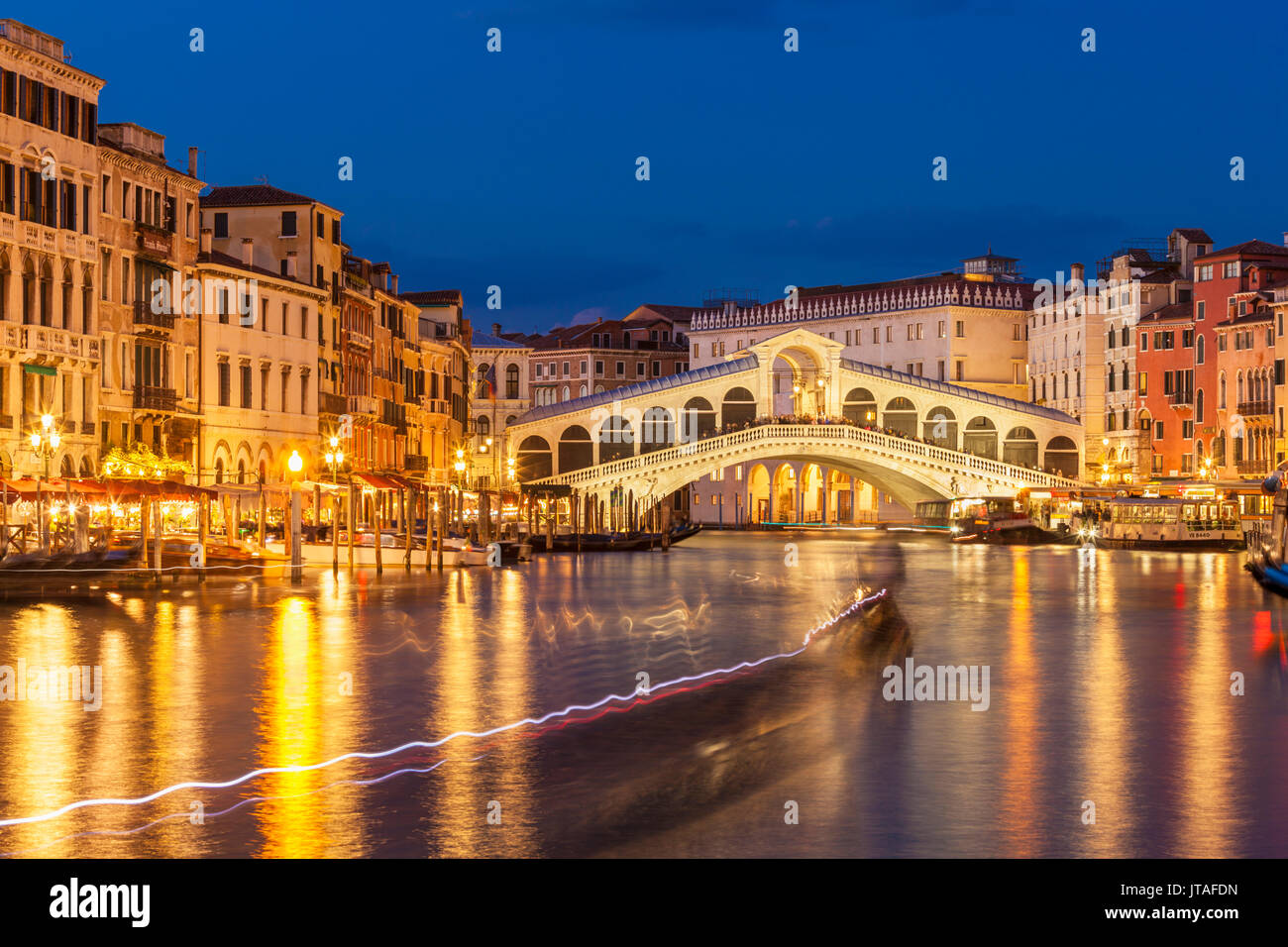 Puente de Rialto (Ponte di Rialto) por la noche con senderos de luz en barco en el Gran Canal, Venecia, UNESCO, Veneto, Italia, Europa Foto de stock