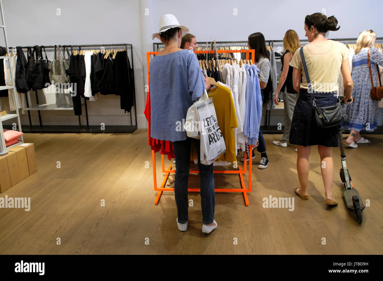 Las mujeres compras para ropa dentro de una tienda boutique tienda en High Street Kensington en el West End de Londres, Reino Unido KATHY DEWITT Fotografía de stock
